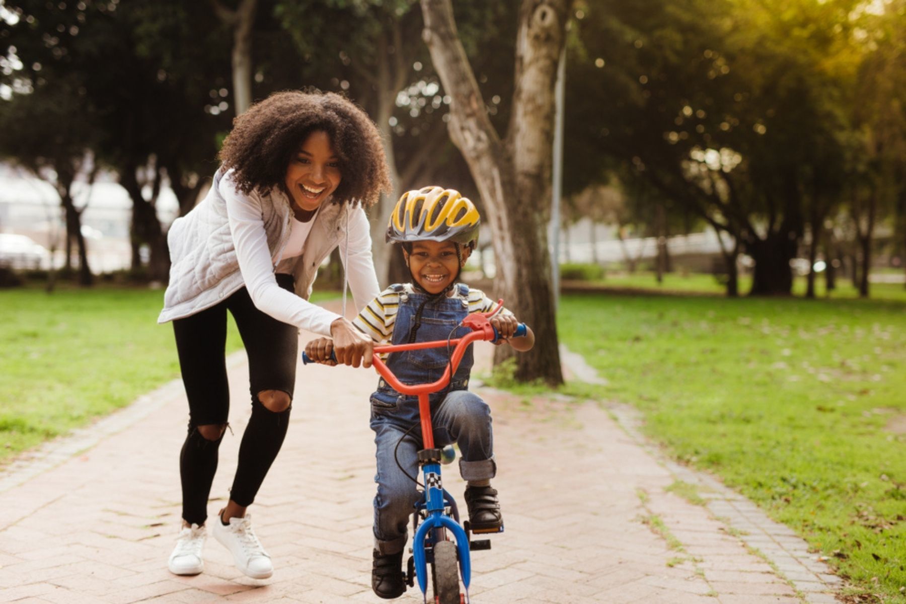 Mother teaching child to ride a bicycle